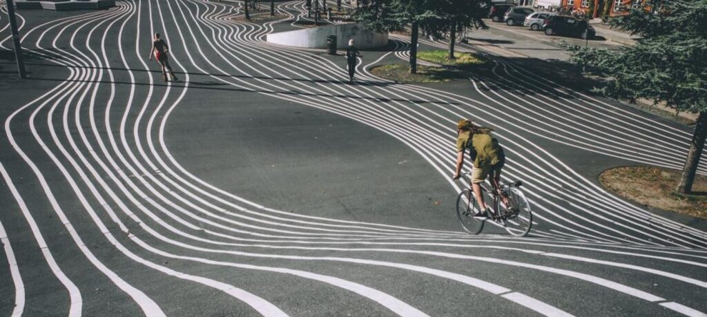 photo of a cyclist on a road with white and black lines in copenhagen denmark