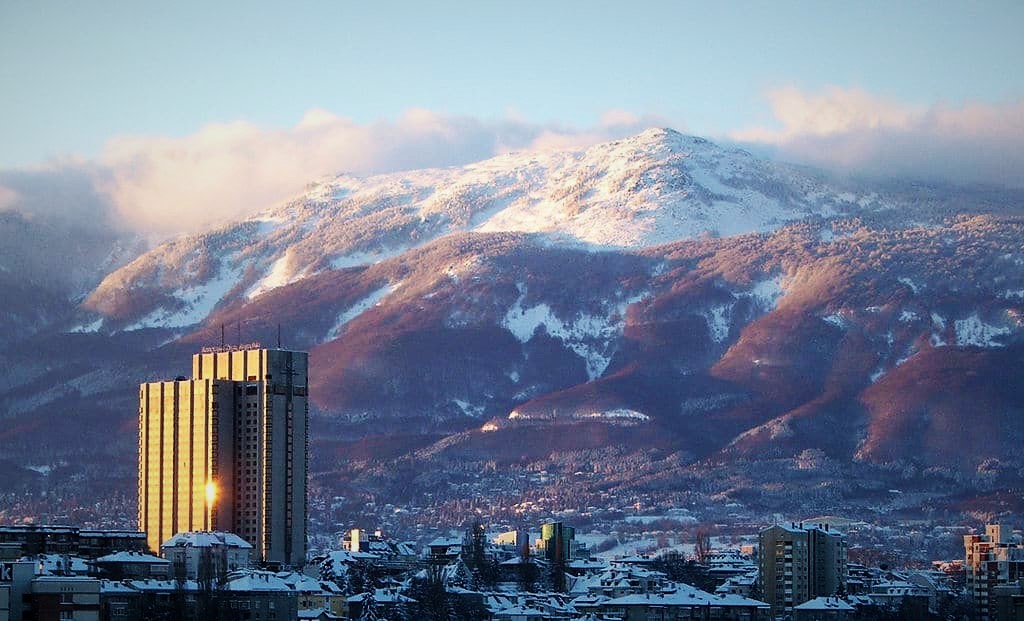 photo of a building in a city with mountain in background in sofia bulgaria