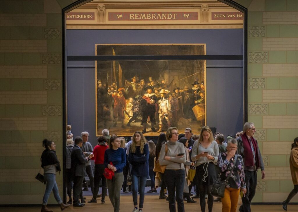 photo of people looking at a piece of art in a museum in amsterdam netherlands