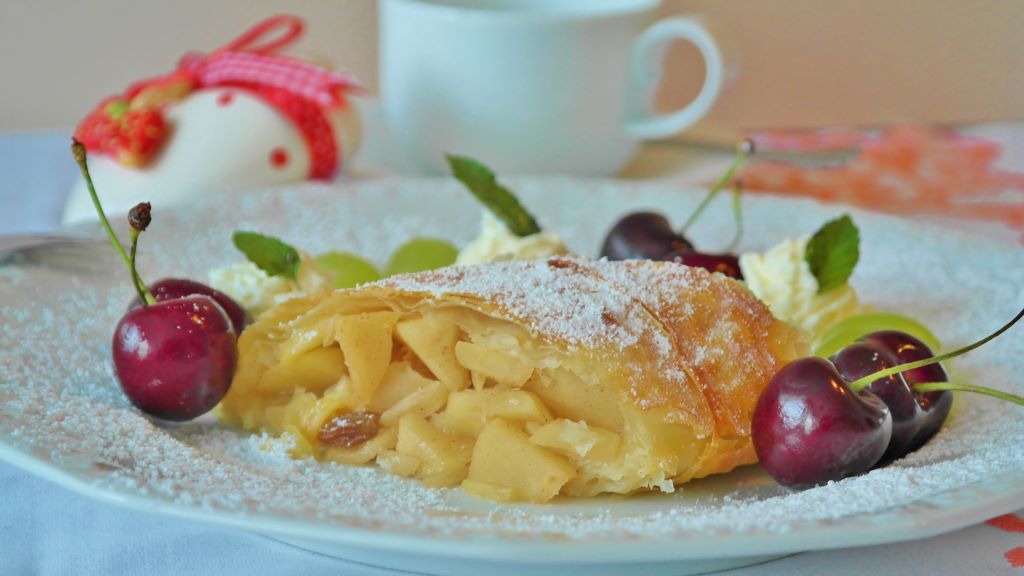 photo of a plate of apple strudel with cherries