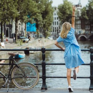 photo of a woman in a blue dress on a bridge in amsterdam netherlands