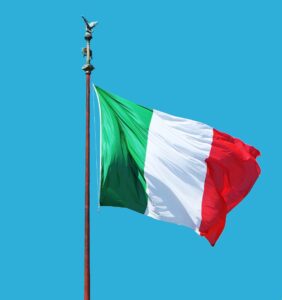 a picture of the italian flage flapping against a blue sky