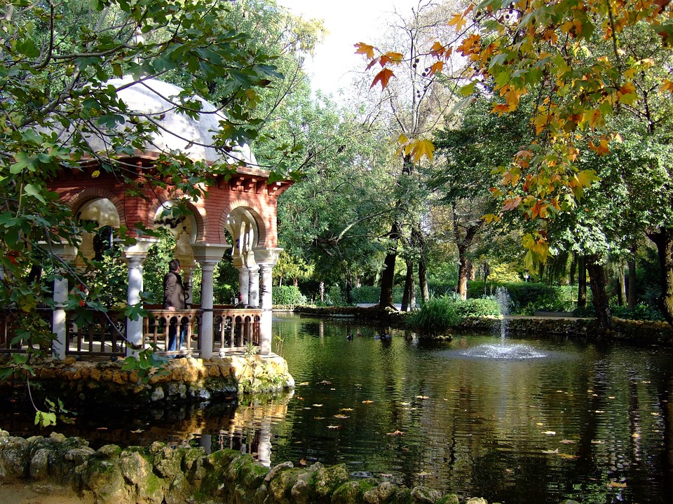 photo of a pond and gazebo surrounded by shrubs and trees