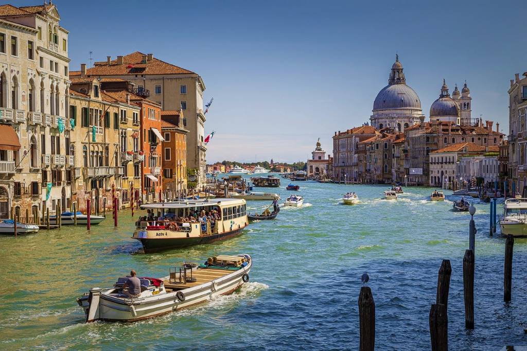 photo of a canal in venice italy crowded with boats and Vaporettos