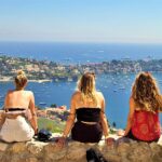 photo of three women looking down on an ocean bay in nice france