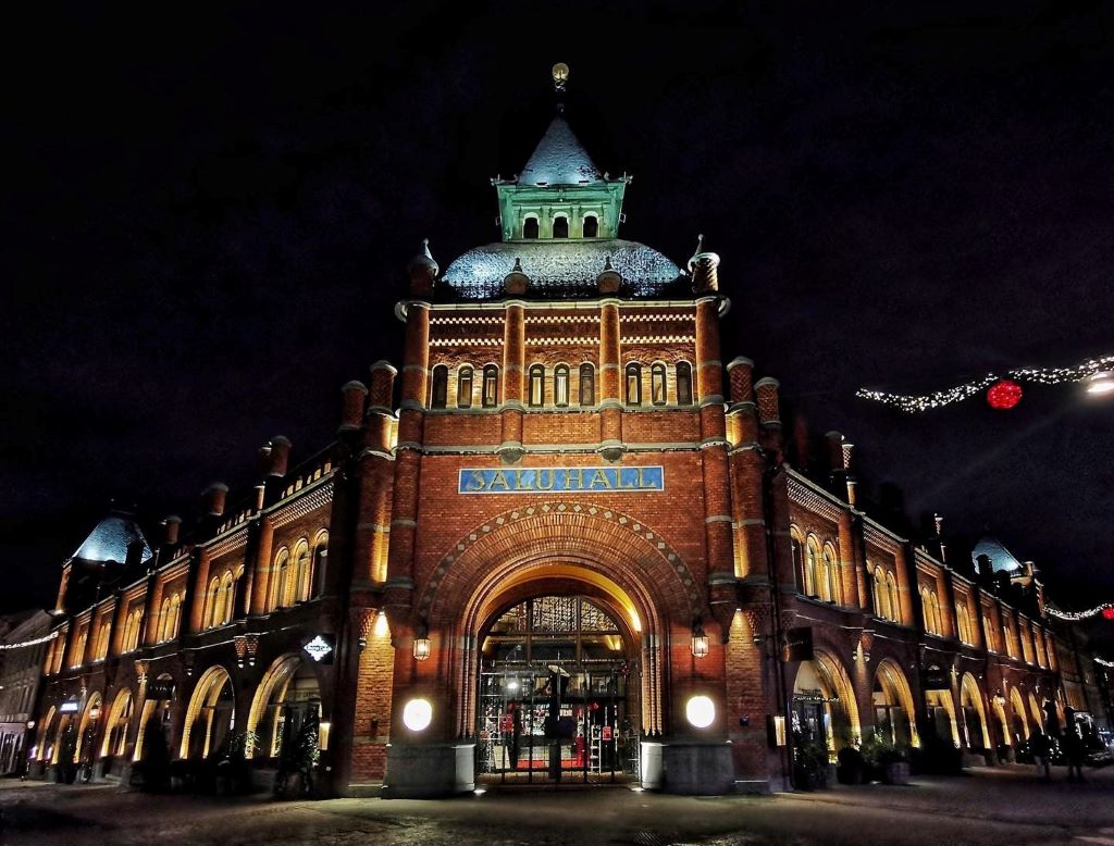 photo of a red brick market hall at night with lights in stockholm sweden