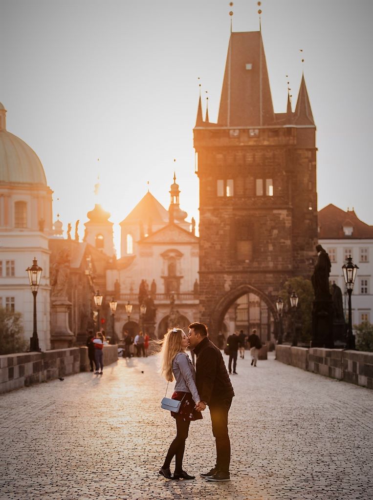 photo of a couple on charles bridge at sunset in prague czech republic
