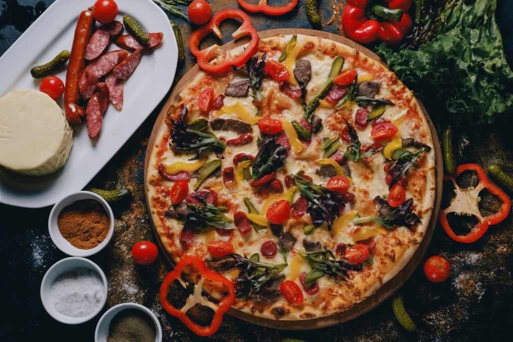 photo of a pizza with ingredients around