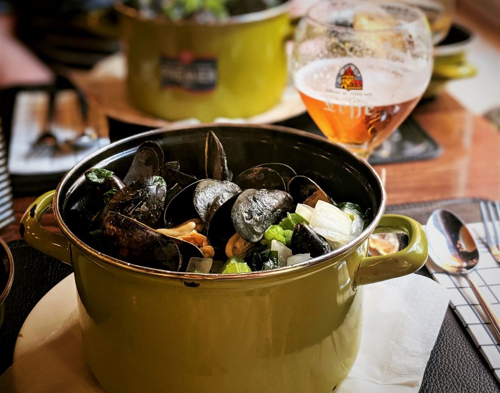 photo of a pot of mussels with a glass of beer in bruges belgium