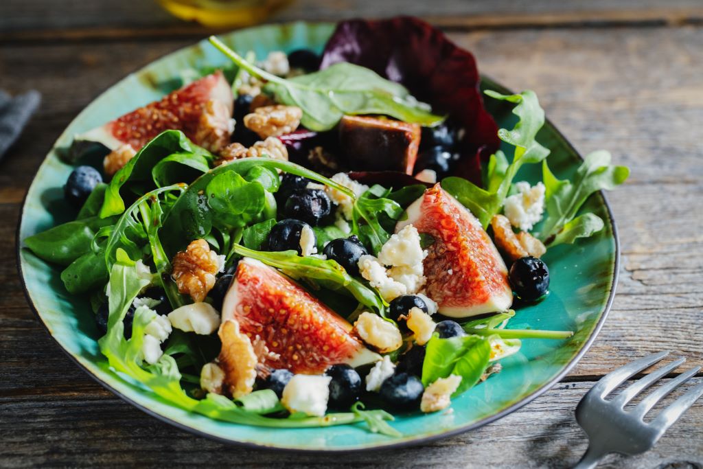 photo of salad with figs cheese nuts, blueberries, on plate