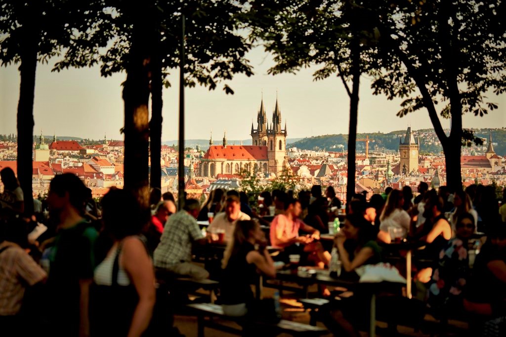 photo of people drinking with a view of a cathedral in prague czech republic
